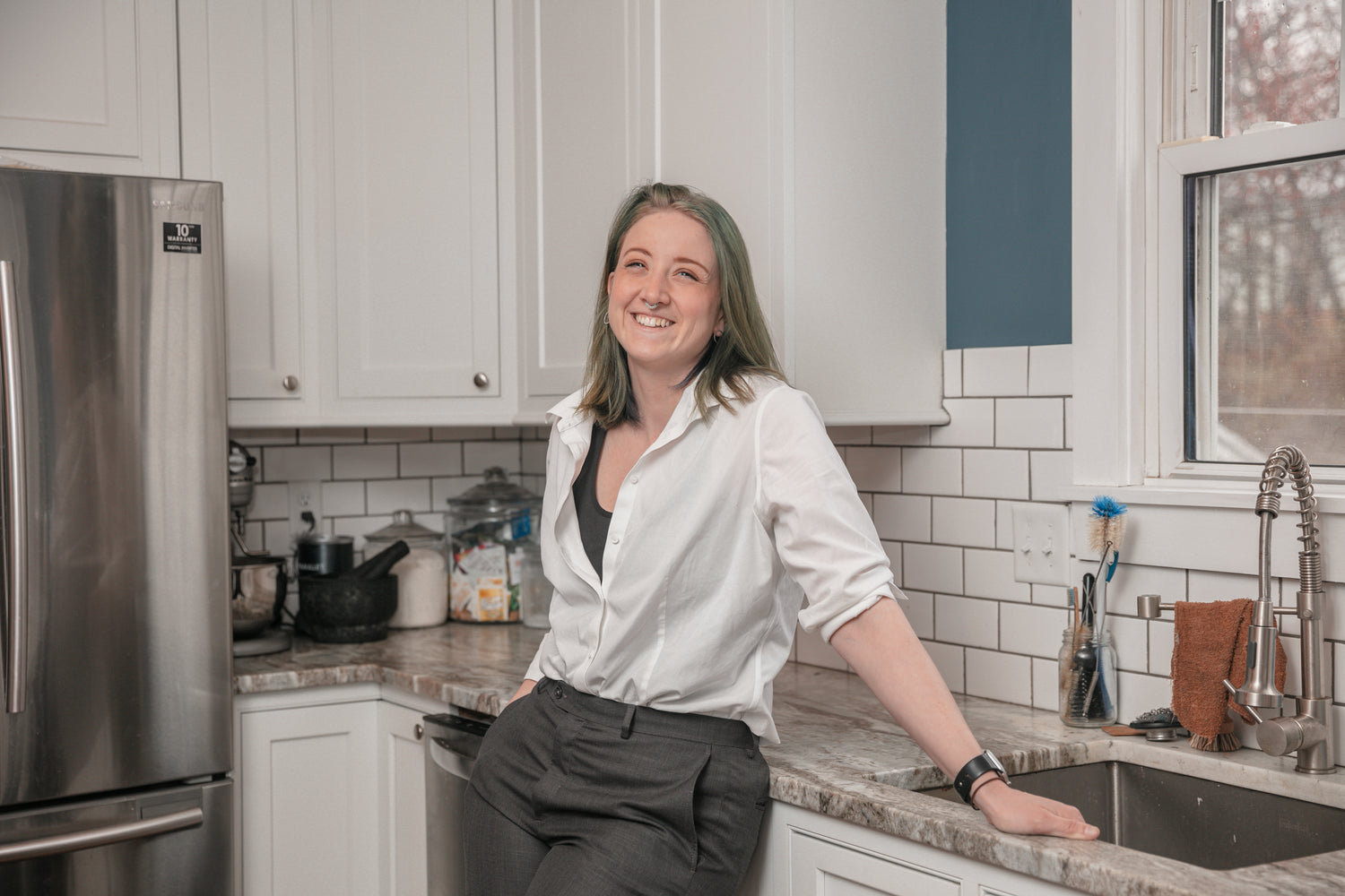 a woman (Elaine Kinney) laughing in her kitchen