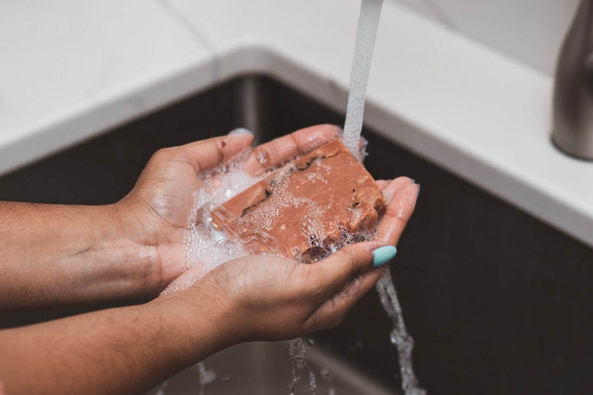 woman washing hands with pink soap