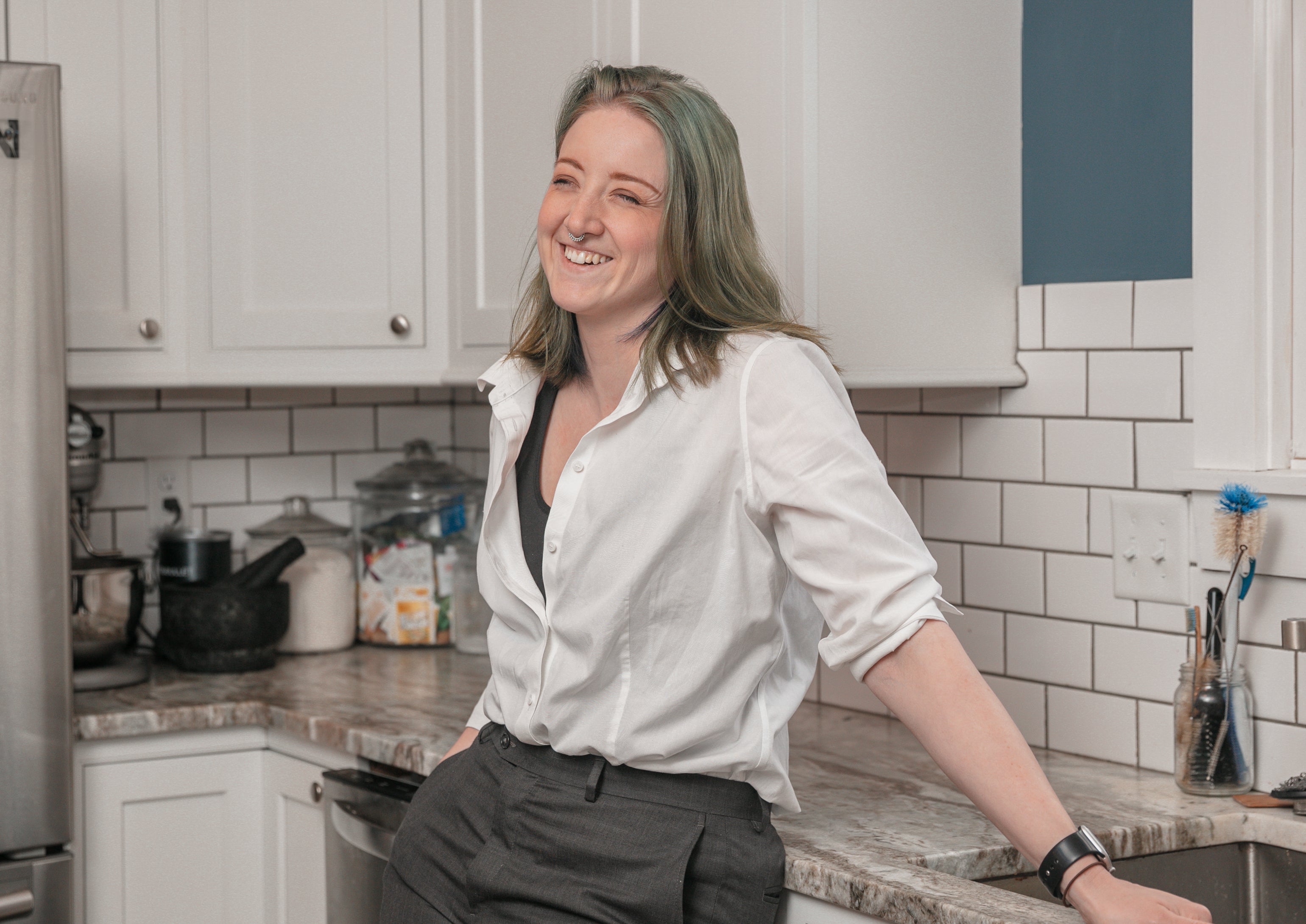 a woman (Elaine Kinney) standing in her kitchen laughing
