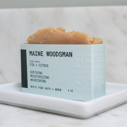 bar of maine woodsman beer soap scented with fir and citrus.