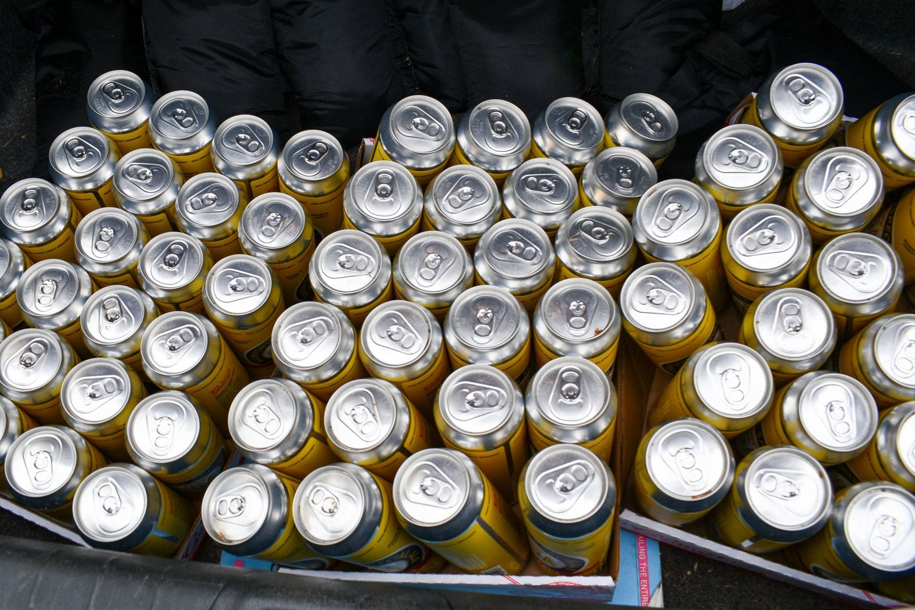 three cases of beer cans being in a car